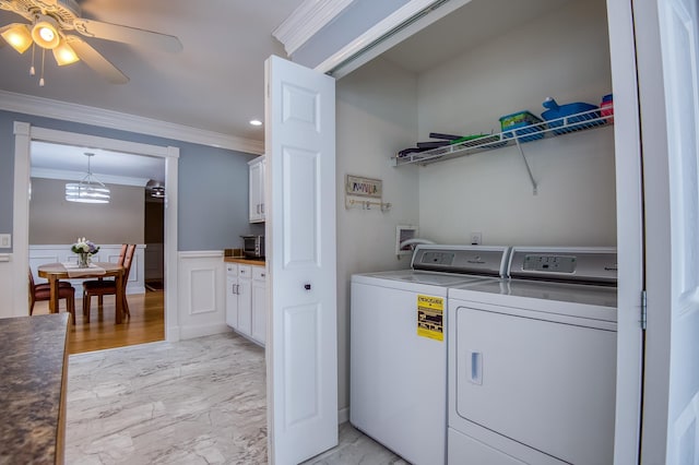 washroom featuring laundry area, washer and dryer, marble finish floor, wainscoting, and crown molding