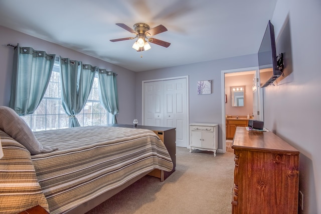 bedroom with ceiling fan, connected bathroom, a closet, and light colored carpet