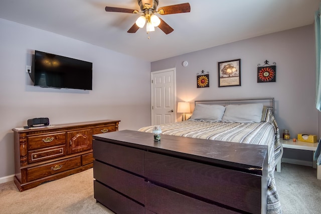 bedroom featuring baseboards, a ceiling fan, and light colored carpet