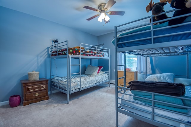 carpeted bedroom with ceiling fan and baseboards