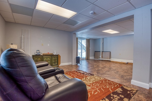 living area featuring a drop ceiling and baseboards