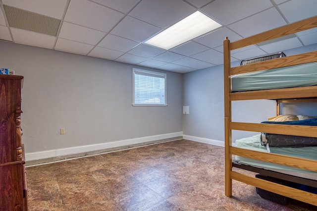 interior space with a paneled ceiling, visible vents, and baseboards