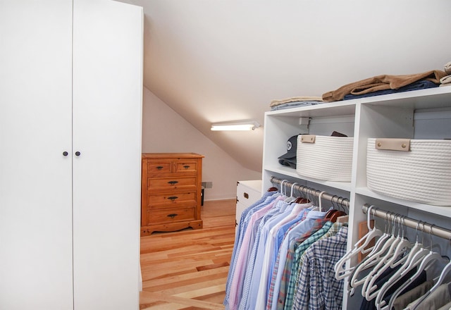 walk in closet featuring vaulted ceiling and light wood-type flooring