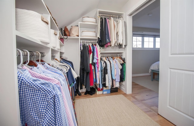 spacious closet featuring lofted ceiling and light wood-style floors