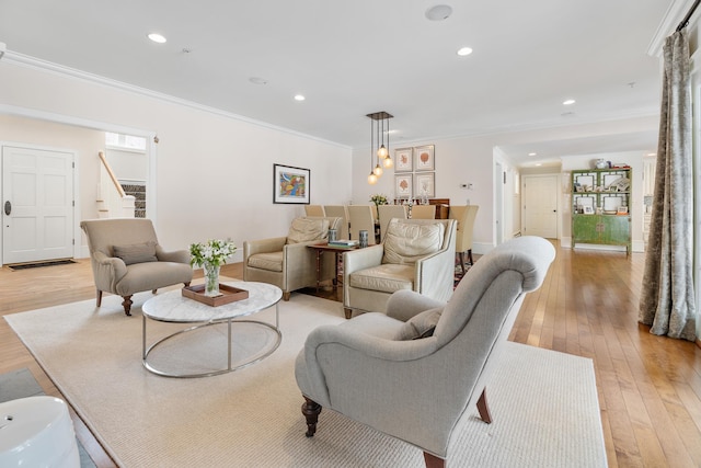 living room with stairway, light wood-style flooring, ornamental molding, and recessed lighting