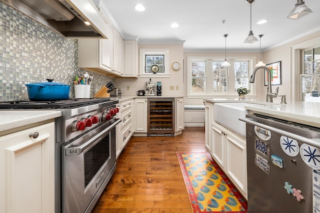 kitchen featuring beverage cooler, dishwashing machine, designer stove, light countertops, and premium range hood