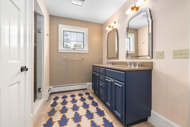 full bathroom featuring a baseboard heating unit, a sink, baseboards, double vanity, and wallpapered walls