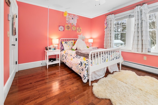 bedroom with dark wood-style floors, baseboards, baseboard heating, and crown molding