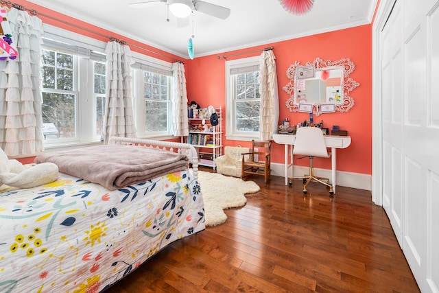 bedroom with dark wood-style flooring, a closet, ornamental molding, ceiling fan, and baseboards