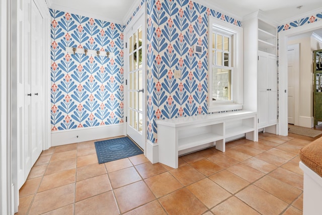 interior space featuring crown molding, baseboards, tile patterned floors, and wallpapered walls