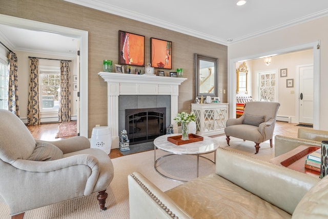 living area featuring light wood-type flooring, ornamental molding, a tiled fireplace, and a baseboard radiator