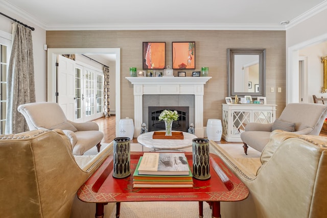 living area with a tiled fireplace, wood finished floors, and crown molding