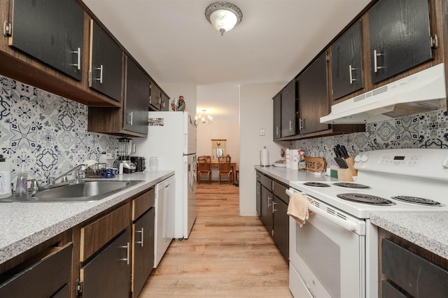 kitchen with white appliances, light countertops, a sink, and under cabinet range hood