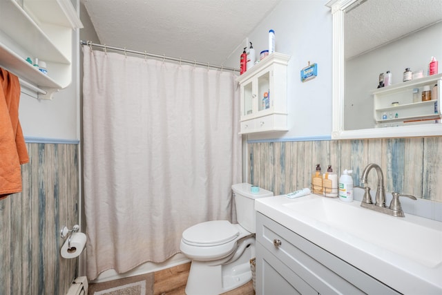 full bathroom featuring wainscoting, a textured ceiling, toilet, and vanity