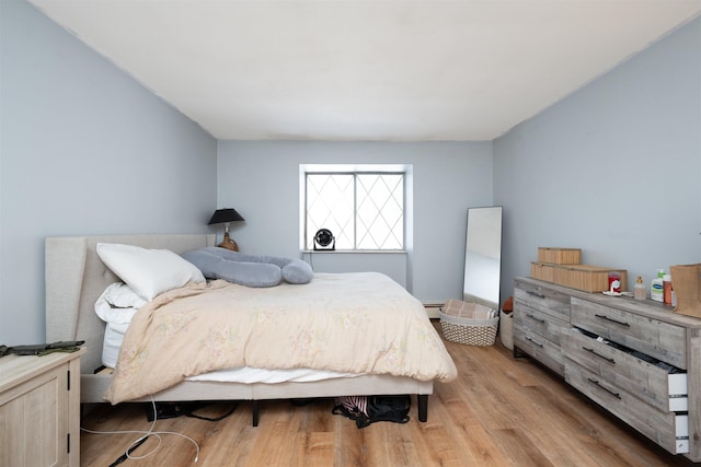 bedroom with baseboard heating and light wood-style flooring