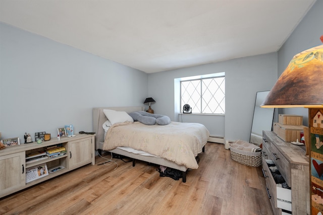 bedroom featuring light wood-style flooring and baseboard heating