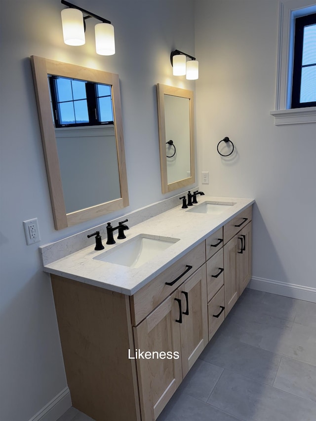 full bath featuring double vanity, baseboards, and a sink