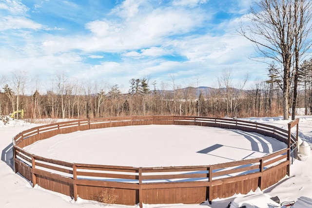 snowy yard featuring a wooded view