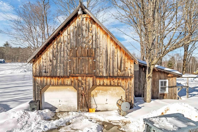 snow covered garage featuring a detached garage