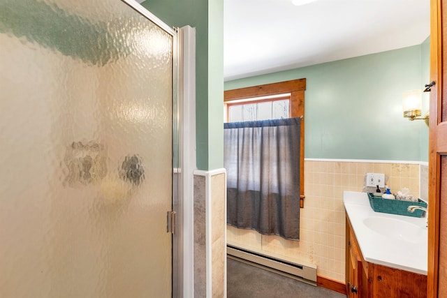 full bath featuring a baseboard radiator, vanity, tile walls, wainscoting, and a stall shower