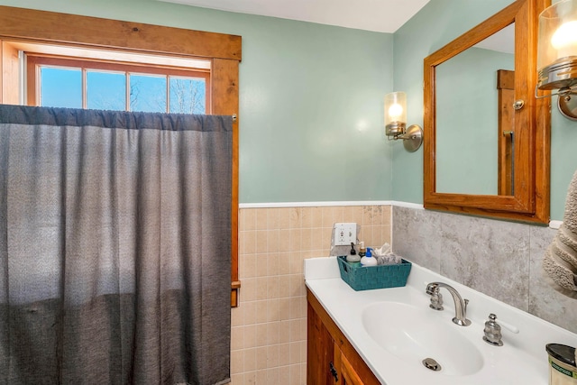 bathroom with a wainscoted wall, vanity, and tile walls