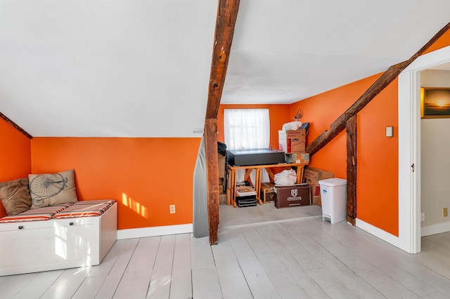 interior space with vaulted ceiling, light wood-style flooring, and baseboards