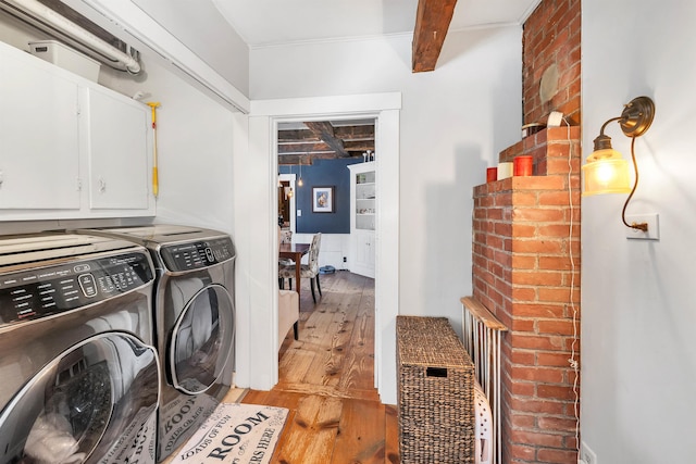 laundry area with light wood-style flooring, washer and clothes dryer, and cabinet space