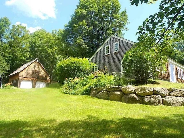 view of yard featuring a garage and an outbuilding