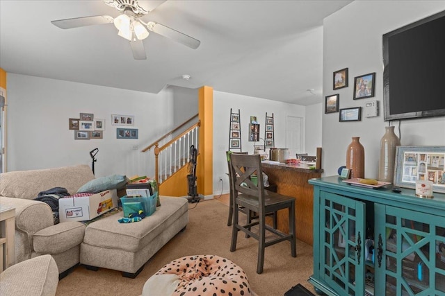 living room with a ceiling fan, light carpet, stairway, and a dry bar