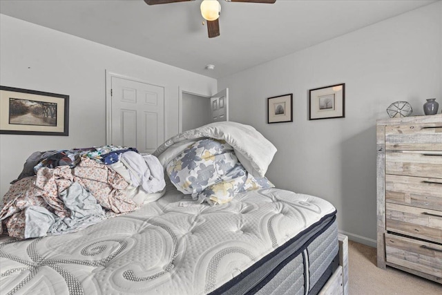 bedroom featuring light carpet, ceiling fan, and baseboards