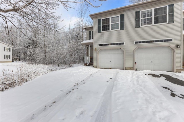 view of snowy exterior featuring an attached garage