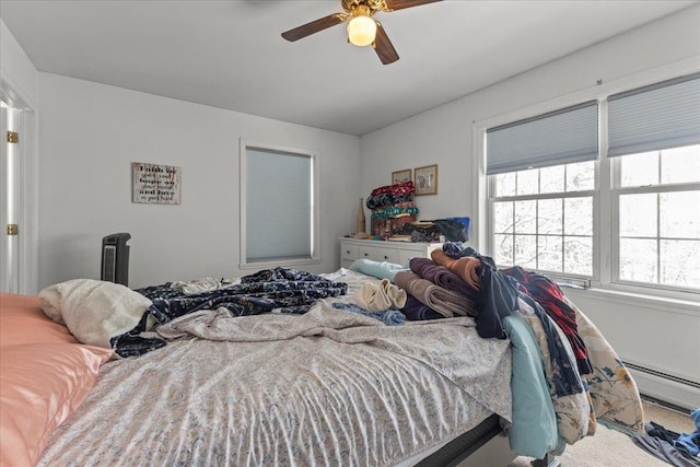 bedroom featuring a baseboard heating unit and a ceiling fan