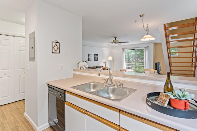 kitchen featuring black dishwasher, white cabinets, decorative light fixtures, light countertops, and a sink