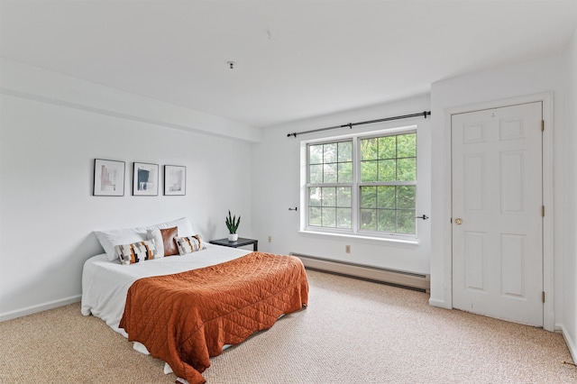 carpeted bedroom featuring a baseboard heating unit and baseboards