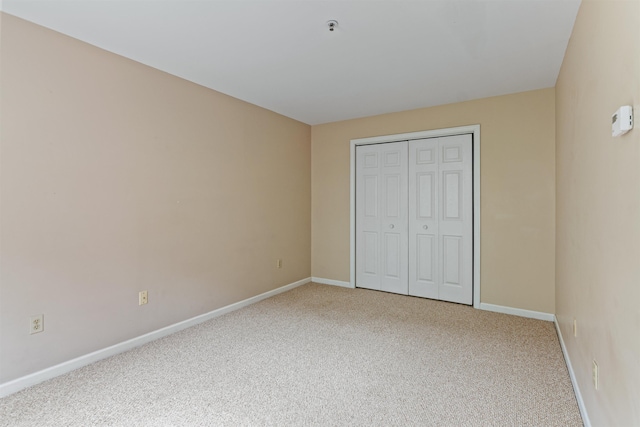 unfurnished bedroom with carpet, baseboards, and a closet