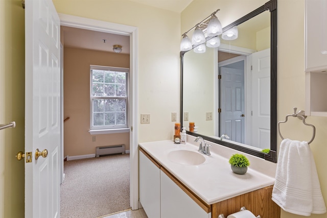 bathroom featuring baseboards, a baseboard heating unit, and vanity