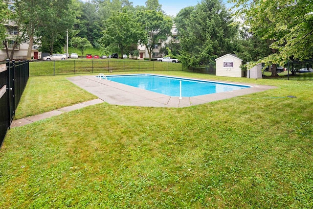 view of swimming pool with a fenced in pool, an outbuilding, a yard, a storage unit, and fence