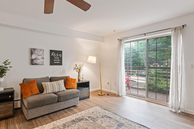 living room with baseboard heating, wood finished floors, and baseboards