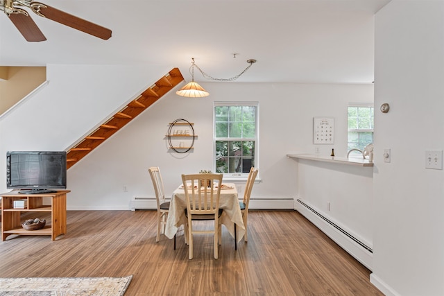 dining area featuring baseboard heating, wood finished floors, and a wealth of natural light