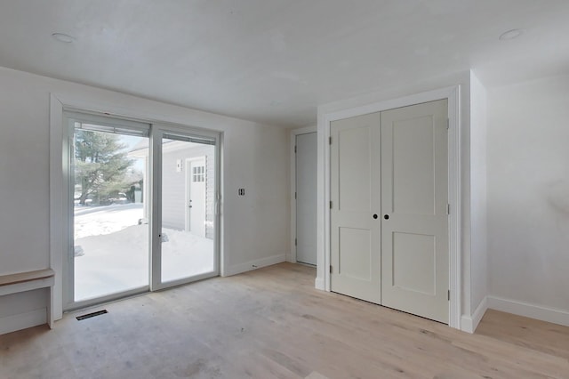 interior space with light wood-style floors, visible vents, and baseboards