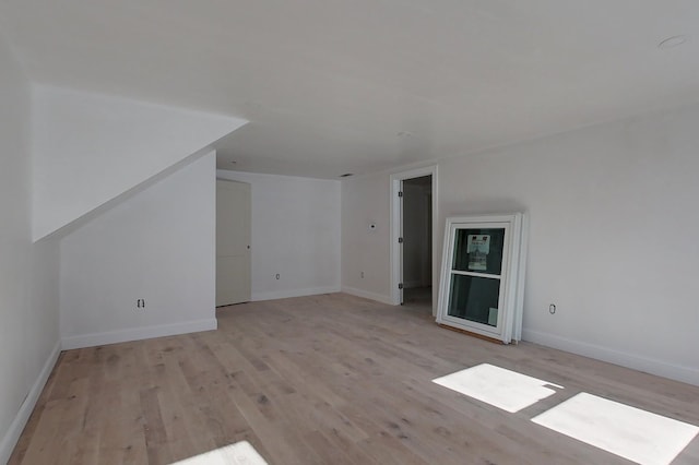 bonus room featuring light wood-style flooring and baseboards