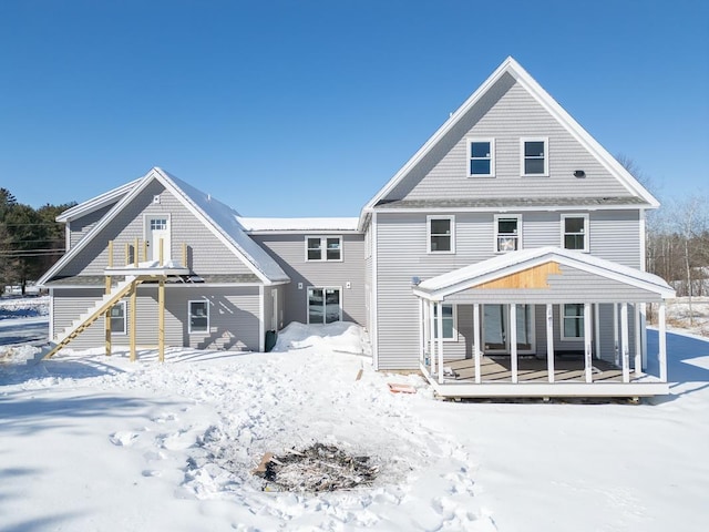 snow covered rear of property with a porch