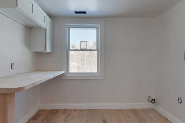 washroom with light wood-style flooring and baseboards