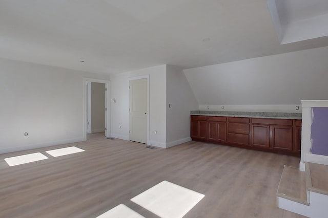 interior space with light wood-type flooring, visible vents, and baseboards