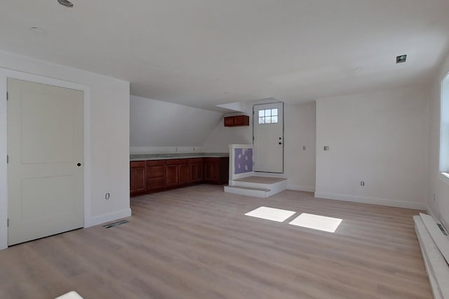 additional living space with light wood finished floors, baseboards, and visible vents