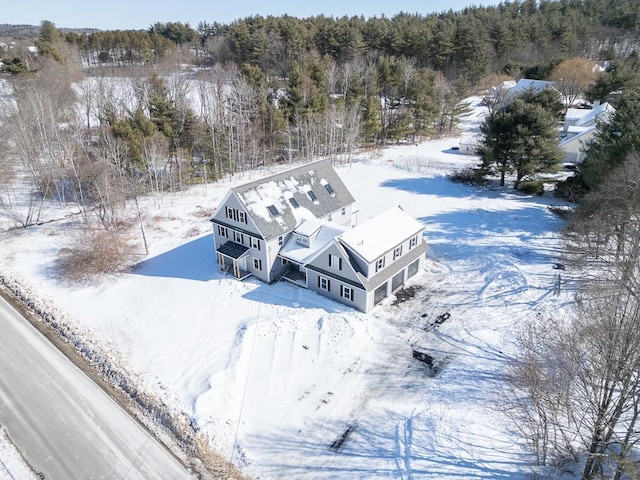 snowy aerial view with a wooded view