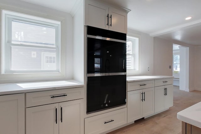 kitchen featuring white cabinets, light wood finished floors, and light countertops