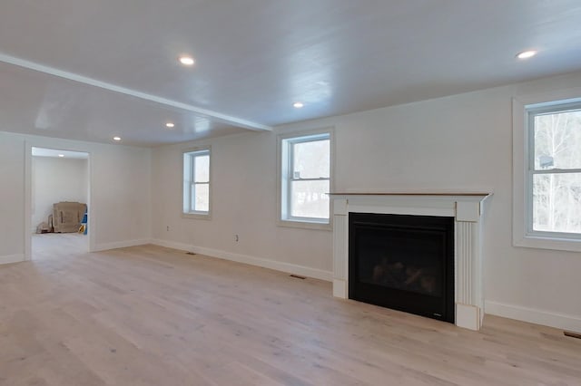 unfurnished living room with light wood-style floors, a fireplace, baseboards, and recessed lighting