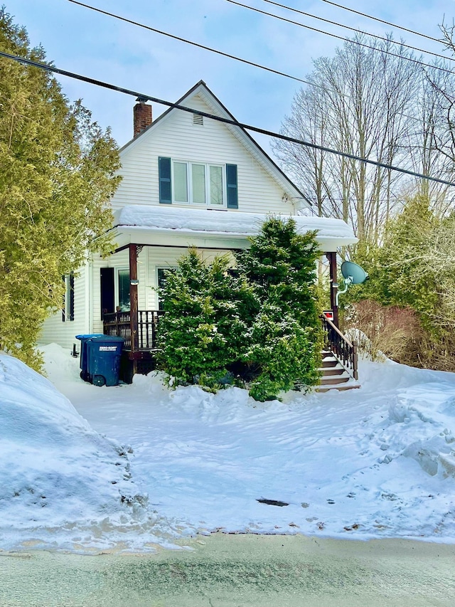 view of snow covered exterior with a chimney