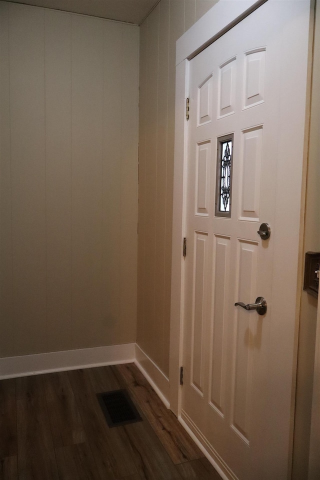 interior space with dark wood-type flooring, baseboards, and visible vents